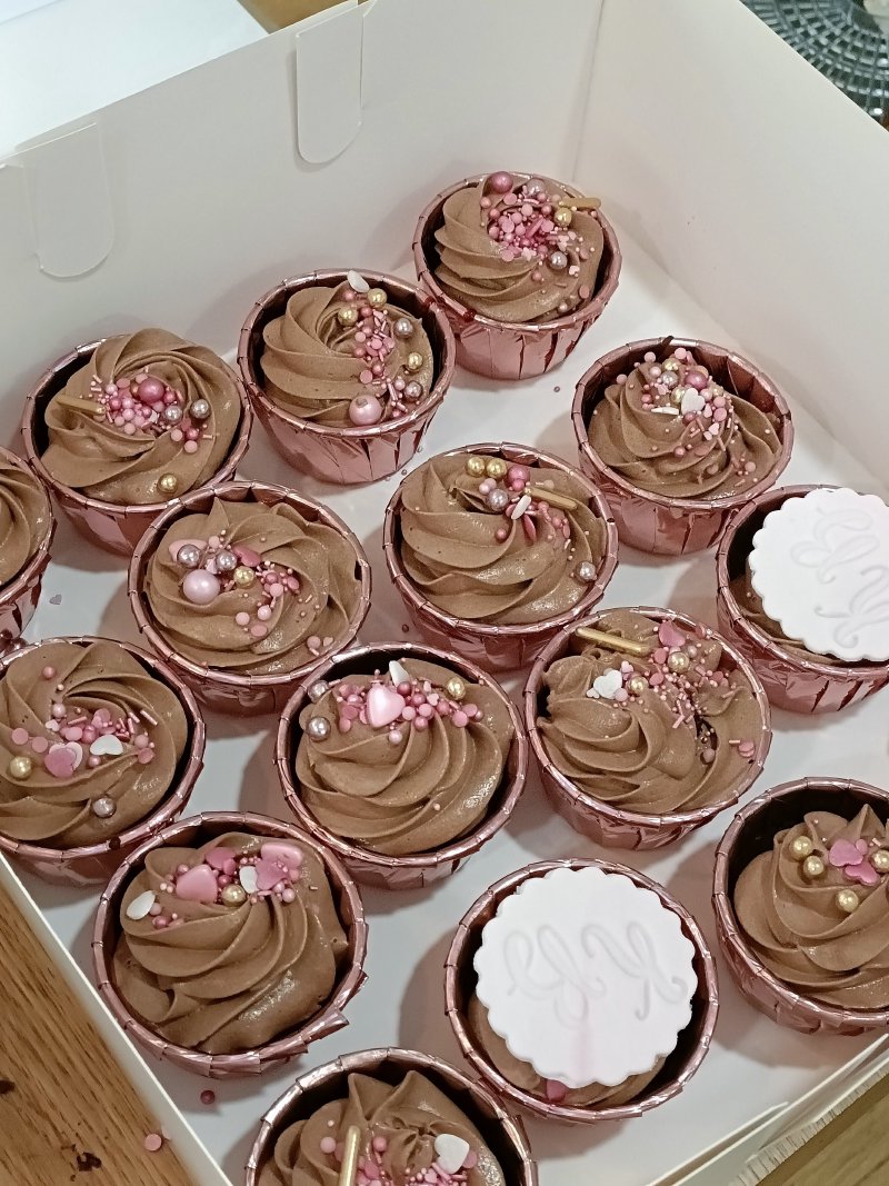 Zestaw czekoladowych cupcake'ów z kremem i różowo-złotymi posypkami