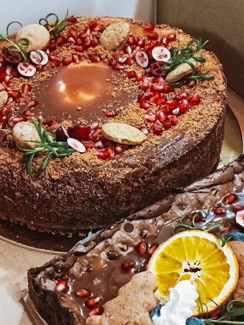 Ciemny tort czekoladowy bogato udekorowany granatem i dodatkami korzennymi.