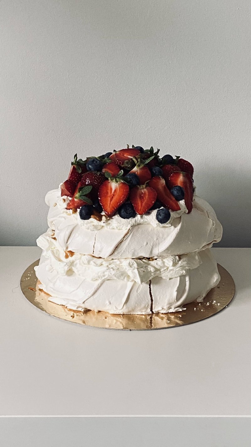 Dwupoziomowa beza Pavlova udekorowana truskawkami i borówkami