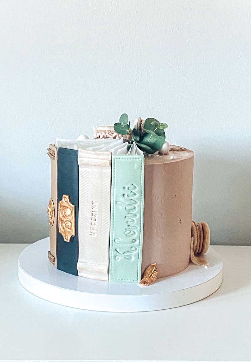 Elegancki tort udekorowany jako stos książek z miętową zawieszką