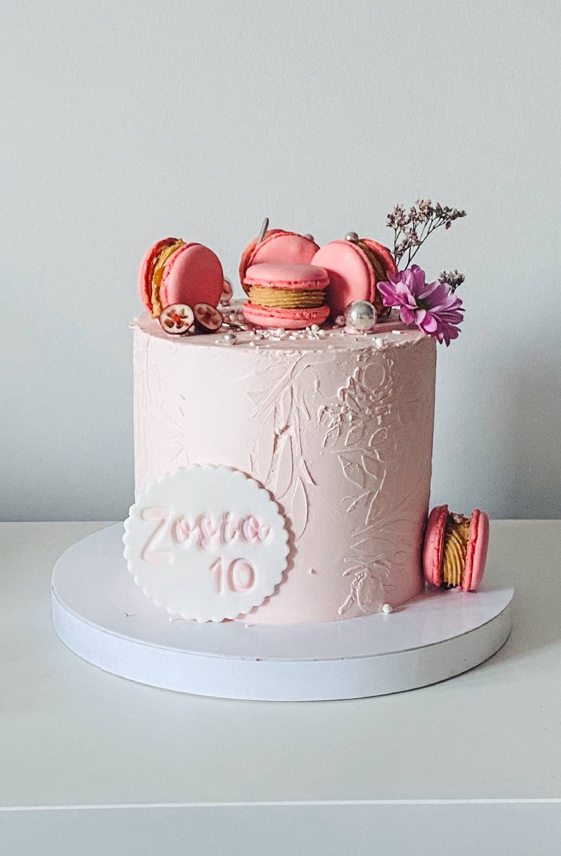 Elegancki tort urodzinowy w kolorze pudrowego różu z makaronikami