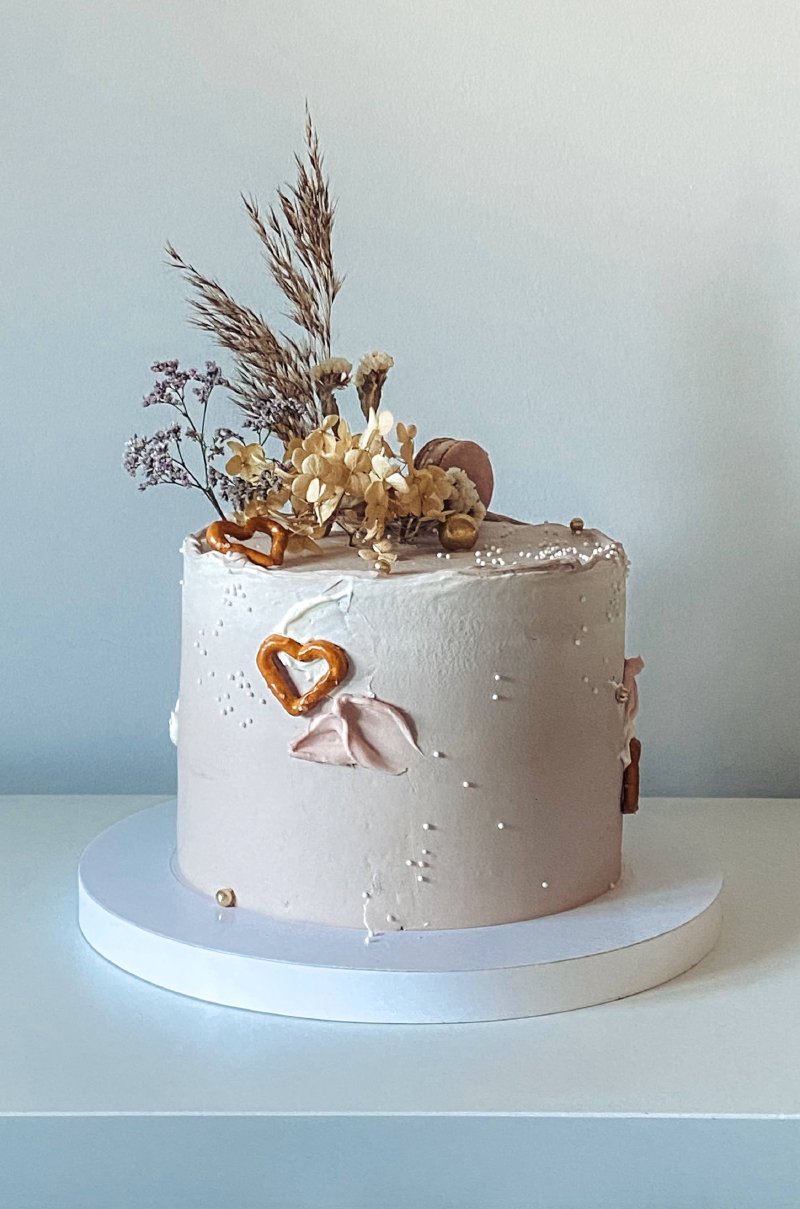 Elegancki tort minimalistyczny z różowym kremem i dekoracjami w stylu boho
