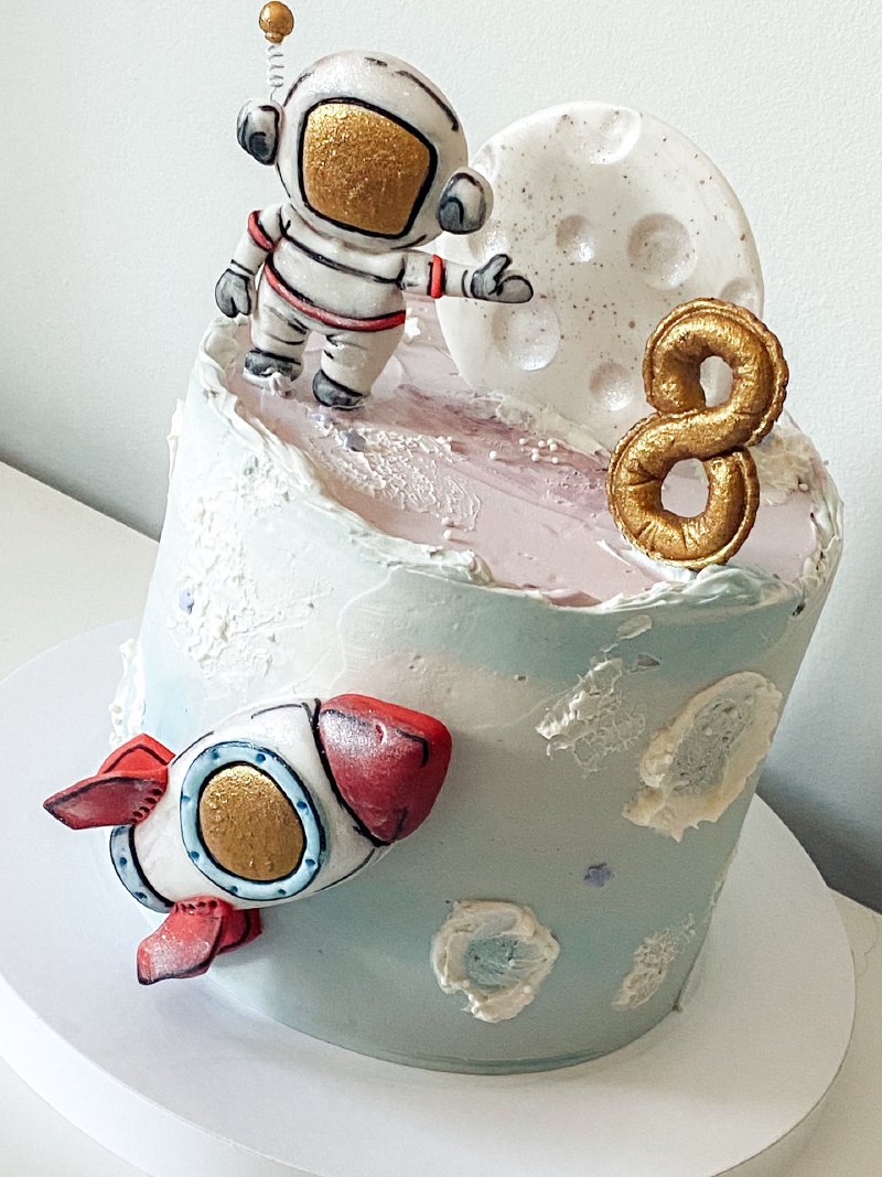 Tort urodzinowy z motywem kosmicznym z figurką astronauty i rakietą