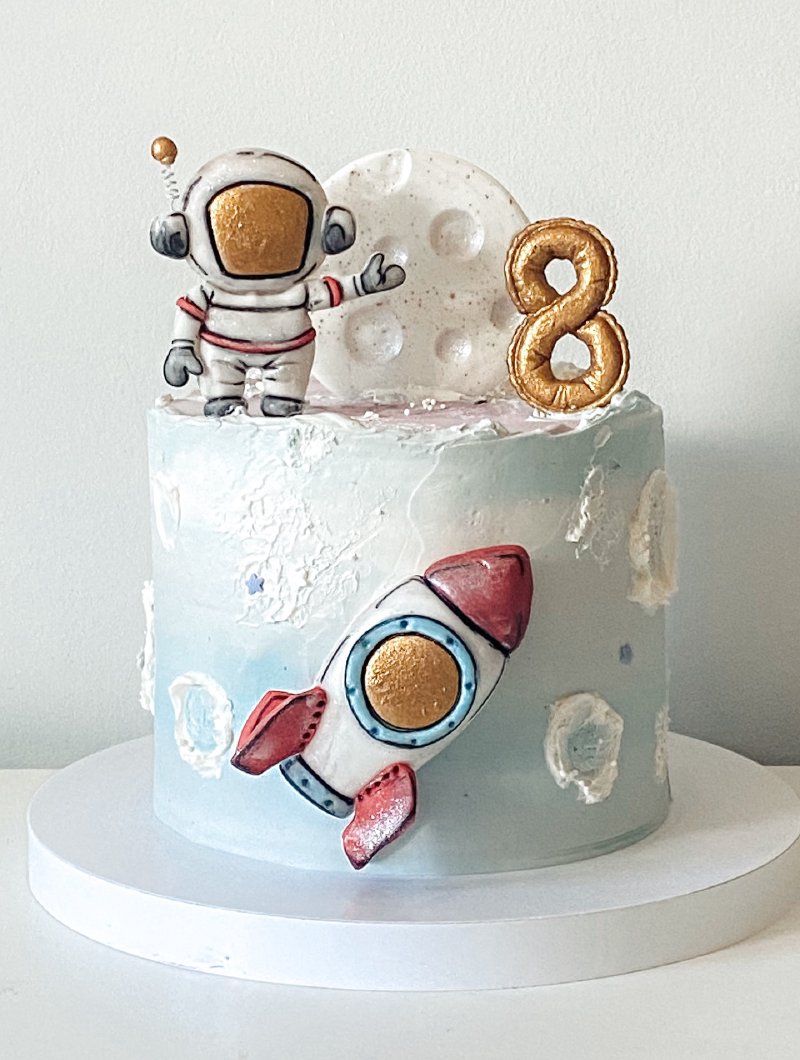 Tort urodzinowy w stylu kosmicznym z figurką astronauty i rakietą
